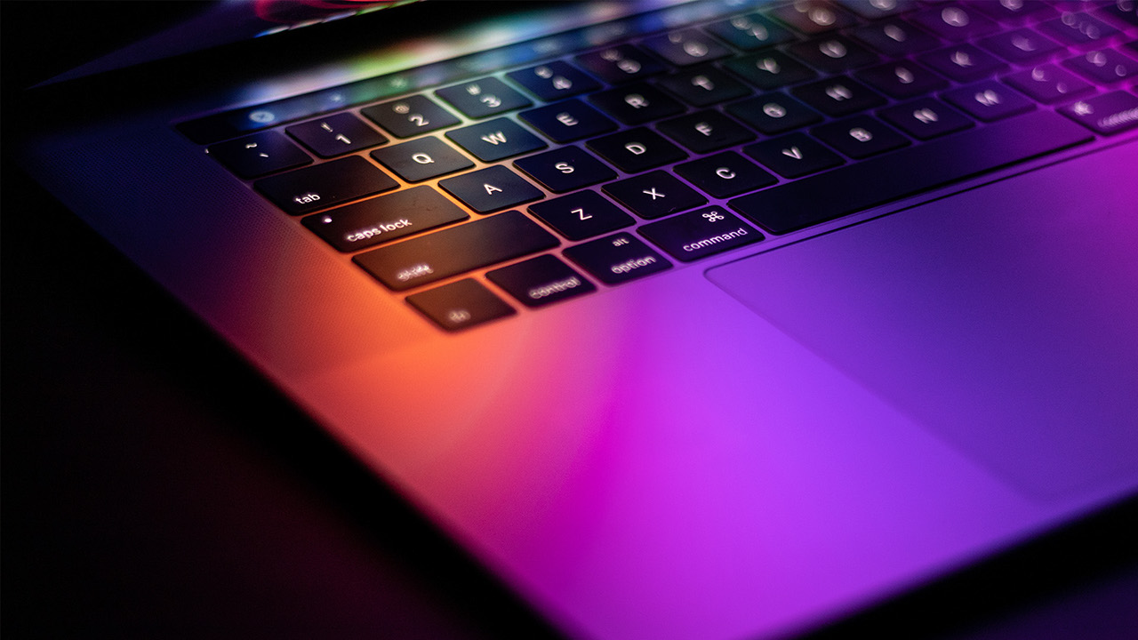 Photograph of laptop with coloured screen glow